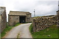 Access road to Whelpstone Lodge passing barn housing tractor