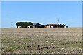 Farm buildings across stubble field above Idmiston