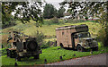 Military-style vehicles beside farm road