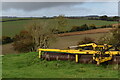 SU0626 : Green grass, yellow machinery, grey sky by David Martin