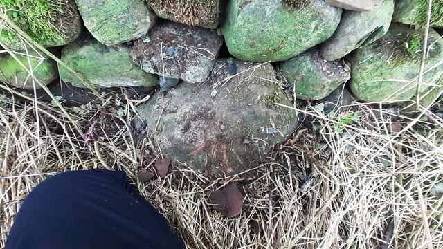 Benchmark on stone at base of wall on SE side A686