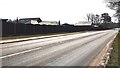 A7 heading south passing Albert Cottage behind wooden fencing