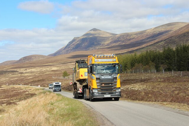 Earth-mover in transit on A836 climbing The Crask