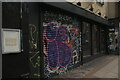 View of street art on the shutter of an empty shop unit on Bethnal Green Road