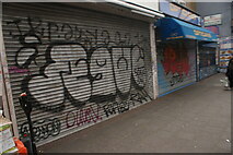 TQ3482 : View of shutter art on a vacant shop unit and G. Bleetman Opticians on Bethnal Green Road by Robert Lamb