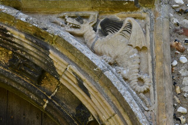 Cratfield, St. Mary's Church:  West doorway spandrels, the woodwose fighting the dragon
