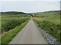 Minor road and bridge crossing the Inverness to Wick railway line