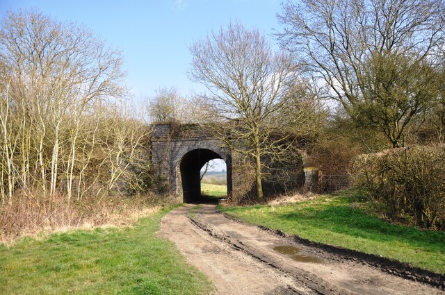 Farm track going under old railway bridge
