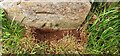 Benchmark on barn attached to house on north side of road in Brough Sowerby