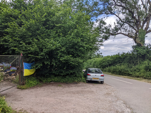 Car parked at the start of Fental Lane, Ukrainian flag on fence