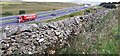 SD5993 : View over wall on west side of minor road towards M6 by Roger Templeman