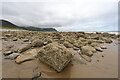 SH7378 : Barnacly boulders on beach SW of Penmaen-Bach by Andy Waddington