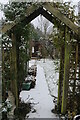 Snowy scene through the garden arch