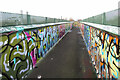 Graffiti-covered footbridge across the railway near Gipsy Lane