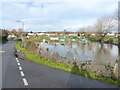 Flooded field with allotments beyond