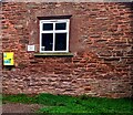 Yellow box on a wall of Skenfrith Village Hall, Monmouthshire