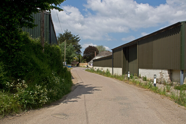 A country road on which is Week Farm, Snell & sons Storage and Winson fuels