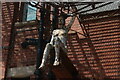 View of a figure sitting on a ledge on the Main Stores building in Trinity Buoy Wharf