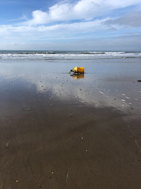 Small yellow buoy on the beach