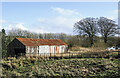 NY2085 : Corrugated metal building at Corrie Common by Trevor Littlewood