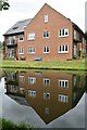 Modern apartment building reflected in Grand Union Canal