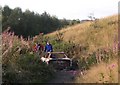 Youths smashing up a burnt out car