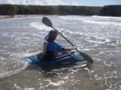 A kayaker paddling out through the surf