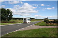 The houses at Achnagarron can be seen to the left of the bus.