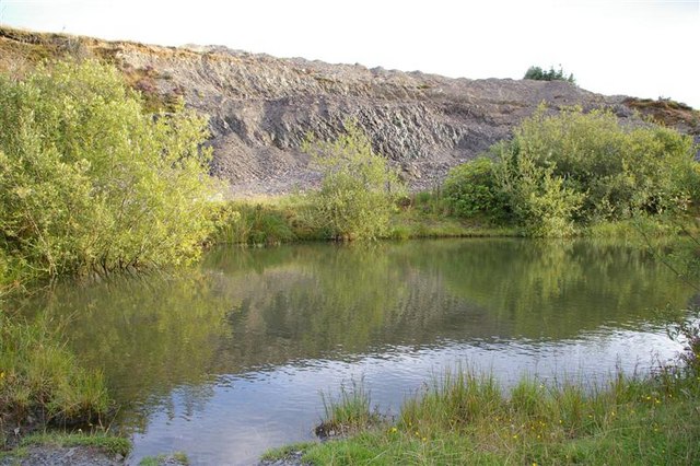 Quarry and small lake in harvested woodland