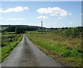 Glasshouses by a straight road  above Darvel