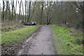 Path through Woodgate Valley Country Park, with dumped car