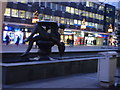 Christmas lights behind mother and child statue.