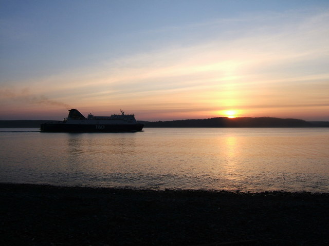 A P&O Ferry in Lochryan sailing to Larne and silhouetted against the setting sun.