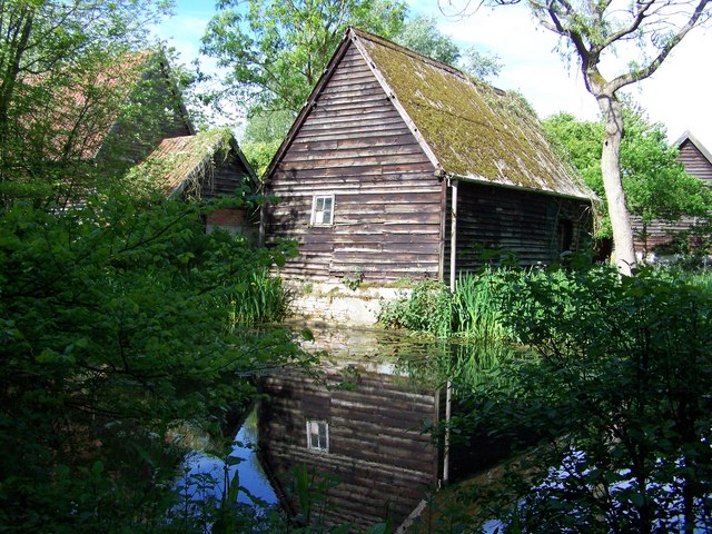 Pond behind farm buildings