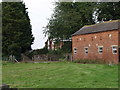 Traditional brick built barn with Morton Hall behind