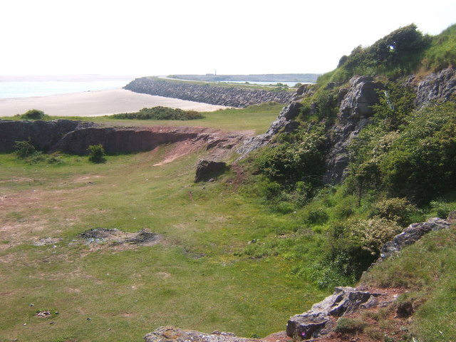 Near Hodbarrow Point, sea wall curving away in the distance