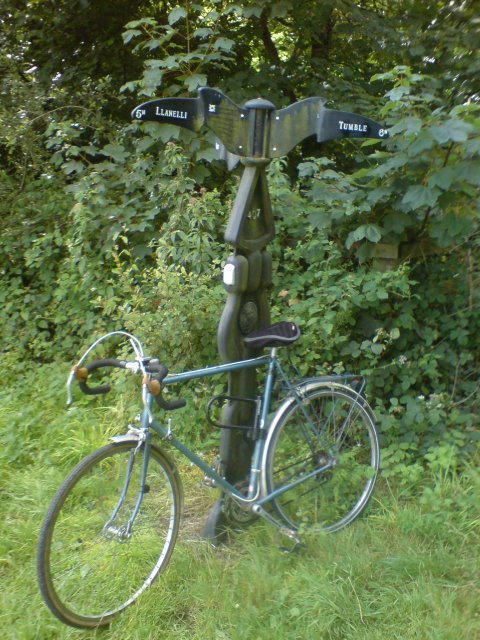 Bike leaning against cycle path mile post