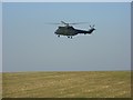 MOD helicopter being flown low over farmland above Shrewton