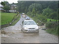 Cars driving through flooded lane in Flockton