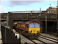 A class 66 stands under Kilburn Priory Road