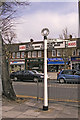 Signpost on pavement near junction Village Road, Bush Hill Road, Ridge Avenue and Church Street