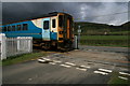 Train and level crossing near Berthddu