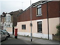 Postbox by flesh coloured house in Goldsmith Avenue