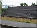 Roof of vernacular single-storey house on new estate, Grey Corries beyond