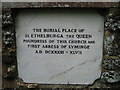 Stone in the S wall of Lyminge Church to mark the burial site of the founder